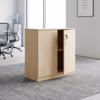 Low-profile wooden office storage cabinet in a light oak finish, featuring two doors with curved silver handles, one door slightly open revealing a central inner shelf, and a key inserted into the integrated lock.