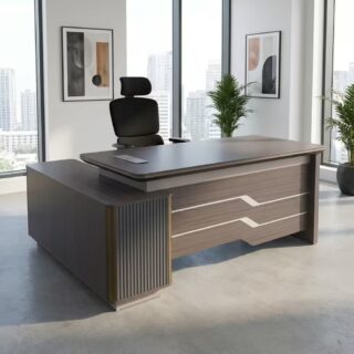 A grey wood grain 1.6m Executive Office Desk featuring a curved-edge tabletop, a brown leather writing insert, a front modesty panel with silver stripe accents, and an integrated side return cabinet with vertical fluting.